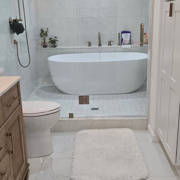 A finished deep clean — freestanding tub, glass shower and marble floor spotless